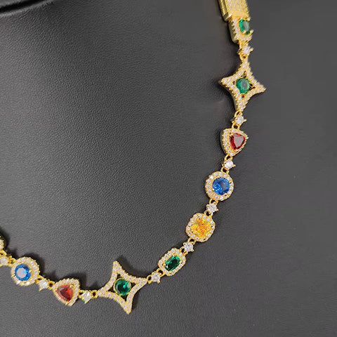 Gold necklace with colorful gemstones on a dark background

