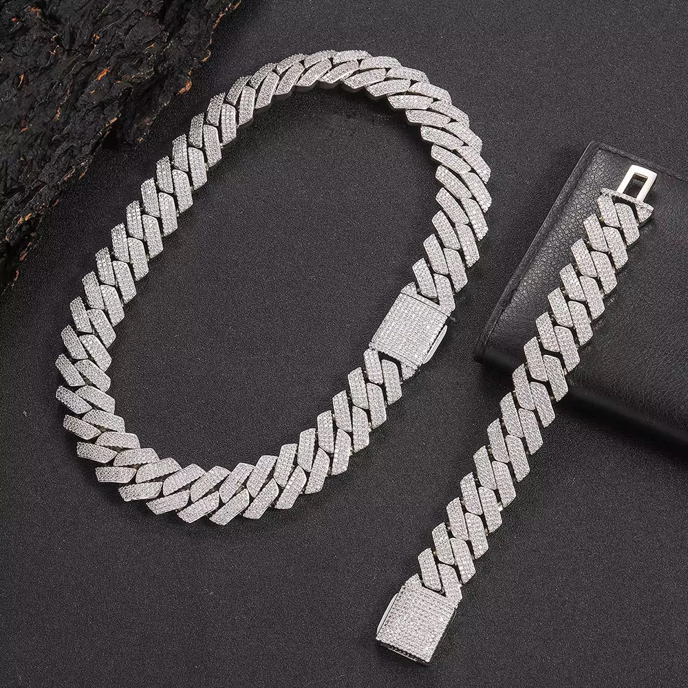 Silver chain necklace and bracelet set on a dark surface


