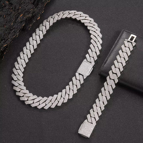 Silver chain necklace and bracelet set on a dark surface

