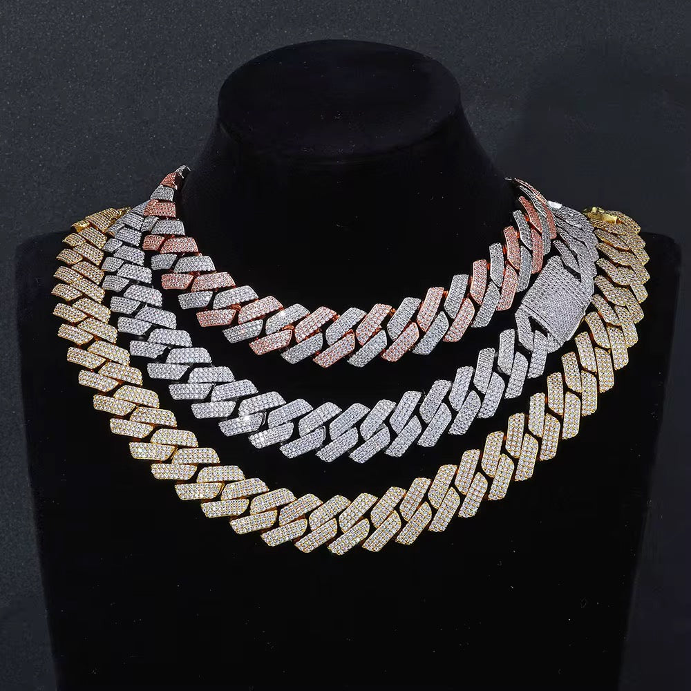 Gold and silver chain necklace on a black mannequin against a dark background

