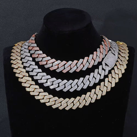 Gold and silver chain necklace on a black mannequin against a dark background

