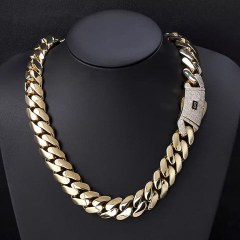 Gold chain necklace with a silver clasp on a black background

