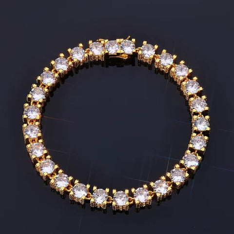 Gold bracelet with clear gemstones on a dark background
