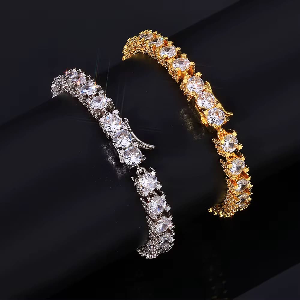 Two diamond-encrusted bracelets, one gold and one silver, on a black background.