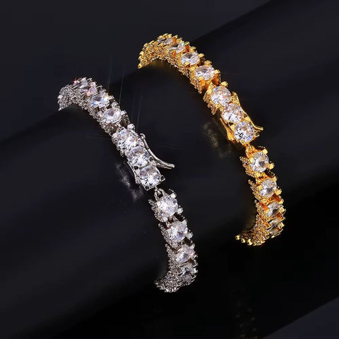 Two diamond-encrusted bracelets, one gold and one silver, on a black background.