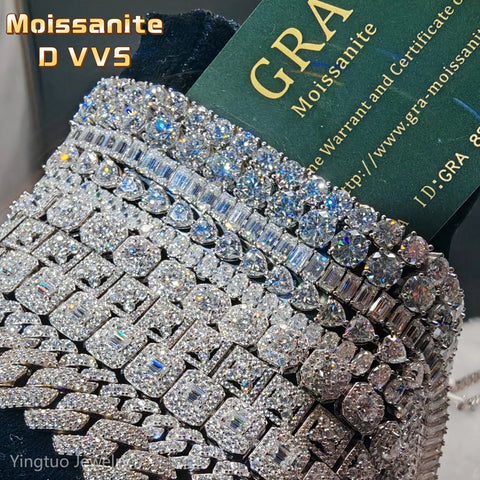 Silver jewelry with embedded gemstones and a GRA Moissanite card in the background.

