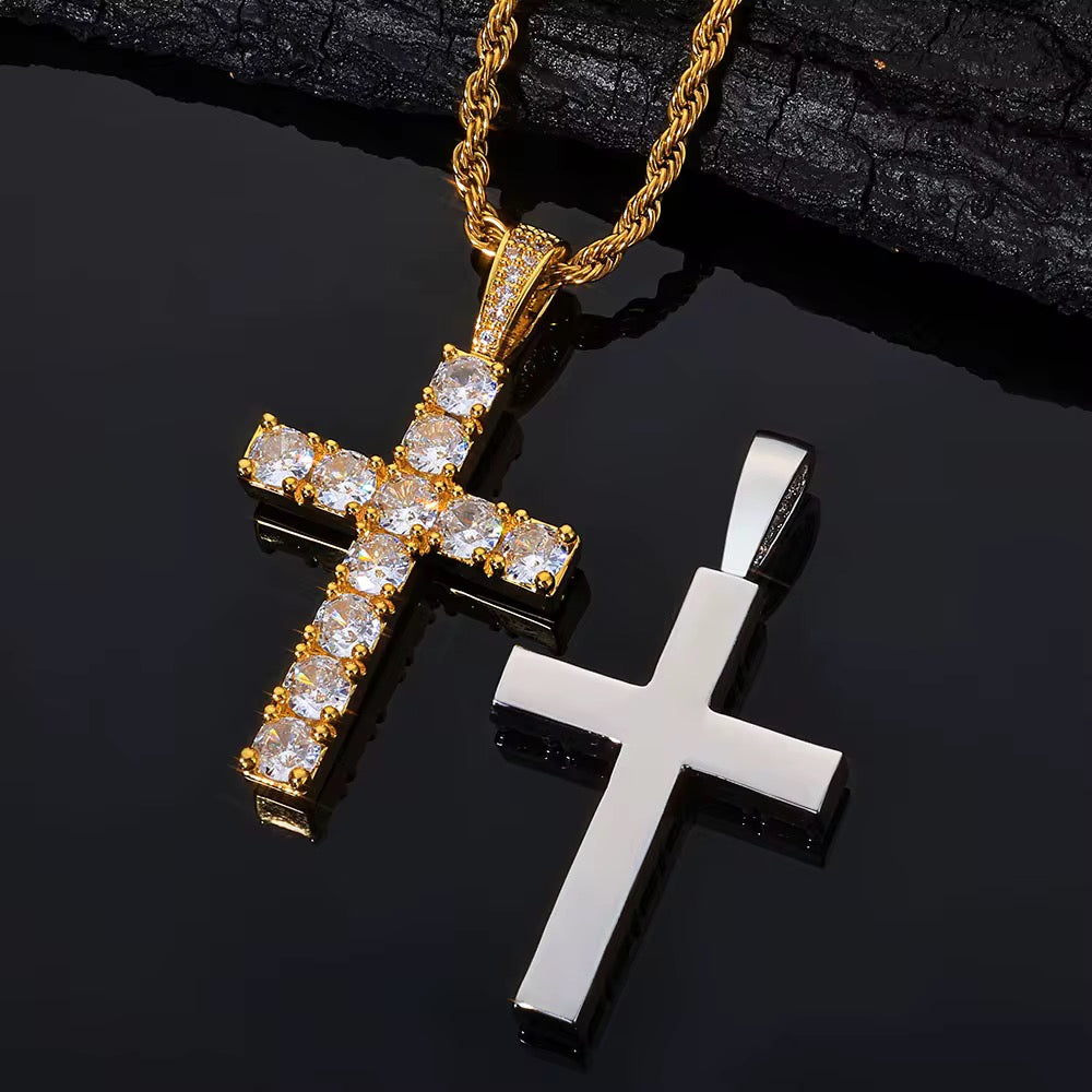 Two cross pendants, one gold and one silver, on a dark surface